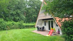 a house with a patio with a table and chairs at Touch of Yellow in Gramsbergen