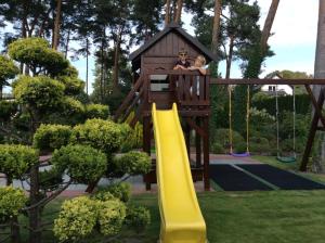 Domek w ogrodzie في غدانسك: شخصان يجلسان على زلاجة في ساحة اللعب