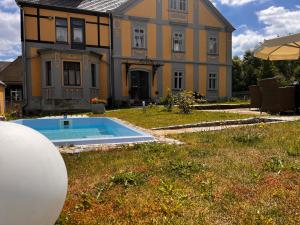 a large house with a swimming pool in front of it at CG Haensch in Großschönau