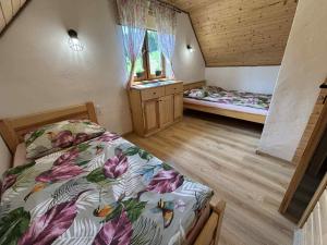 a bedroom with two beds and a sink in it at Bieszczadzki Bohater Domki 533-502-137 in Polańczyk