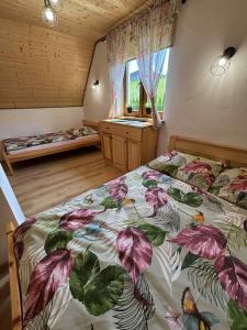 a bedroom with two beds and a window at Bieszczadzki Bohater Domki 533-502-137 in Polańczyk