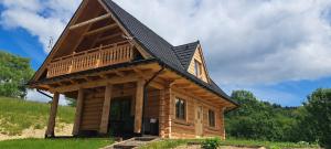 a log cabin with a gambrel roof at Dom U Eskulapa in Lutowiska