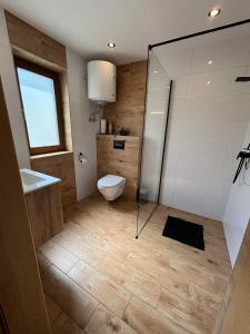 a bathroom with a toilet and a glass shower at Bieszczadzki Bohater Domki 533-502-137 in Polańczyk +45 photos