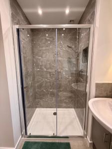a shower with a glass door in a bathroom at The Wee Hoose in Fife +2 photos
