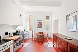 a kitchen with a table and a dining room at Escapade elegante dans un ecrin d histoire in Hyères