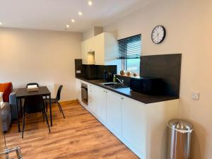 a kitchen with a table and a clock on the wall at The Wee Hoose in Fife