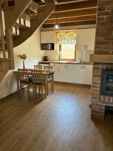 a kitchen with a table and chairs and a fireplace at Bieszczadzki Bohater Domki 533-502-137 in Polańczyk