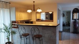 a kitchen with two chairs at a counter with a mirror at PhilVik in Lannion +8 photos