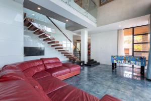 Villa Luxury Hồ Bơi View Biển Bãi trước Vũng Tàu في فنغ تاو: أريكة حمراء في غرفة معيشة مع درج