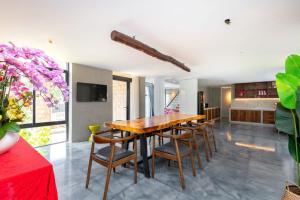 Villa Luxury Hồ Bơi View Biển Bãi trước Vũng Tàu في فنغ تاو: غرفة طعام مع طاولة وكراسي خشبية