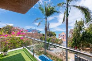 Villa Luxury Hồ Bơi View Biển Bãi trước Vũng Tàu في فنغ تاو: اطلالة من بلكونة منزل فيه نخيل