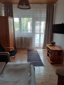 a living room with a couch and a large window at Ibolya in Balatonfüred