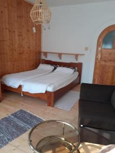 a living room with a bed and a glass table at Ibolya in Balatonfüred
