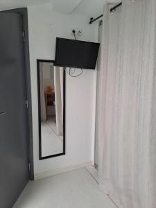 a mirror in a room next to a curtain at Casa das Bonecas in São Martinho do Porto