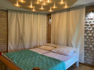 a bed in a bedroom with lights on the ceiling at Sarajevo Villa with Garden, Kids Pool and Calm Area in Osenjače +27 photos