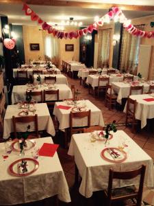 un comedor con mesas con manteles blancos en Albergo Ristorante Valsugana en Primolano