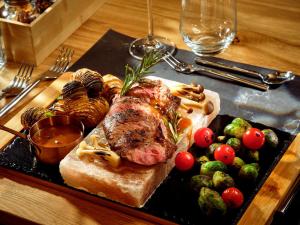 a plate of food with meat and vegetables on a table at Baltic Jet Luxury Aparthotel in Ustronie Morskie +73 photos
