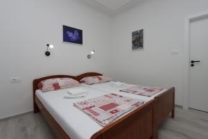 a bedroom with a bed with white sheets and pillows at Apartments NOVALJA, Burin Bok 5 in Novalja