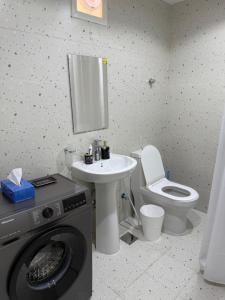 Un baño con lavadora y lavabo. en Brand new - Stylish Studio Near to Yas & Airport, en Abu Dabi