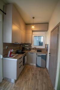 a kitchen with white cabinets and a wooden floor at vagia's studio in Alexandroupoli +30 photos
