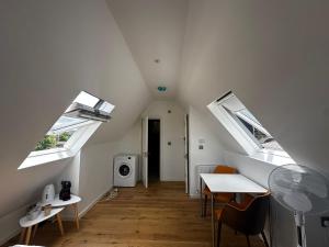 an attic room with a table and two windows at Keysan House 1 in London