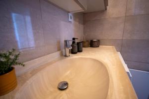 a bathroom sink with bottles on top of it at vagia's studio in Alexandroupoli