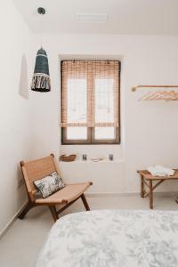a bedroom with a bed and a chair and a window at Domus Templi in Caravaca de la Cruz
