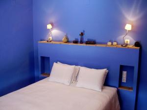 1 dormitorio azul con 1 cama con almohadas blancas en Sharíqua, en Jérica