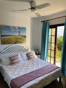 Reserva septiembre,octubre Apartamento piscina y playa junto Cap D Artrutx cerca Ciudadela في سون كسورغير: غرفة نوم بسرير أبيض مع منارة