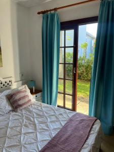 Reserva septiembre,octubre Apartamento piscina y playa junto Cap D Artrutx cerca Ciudadela في سون كسورغير: غرفة نوم بسرير ونافذة ذات ستائر زرقاء +28 صورة