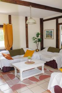 a living room with two beds and a table at La villa Lambert-Longière in Monnai +26 photos