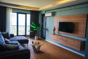 a living room with a couch and a flat screen tv at Lemon Suites & Restaurant in Korucuk