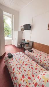 a hotel room with two beds and a desk and a table at Hôtel Belle Meunière in Nice