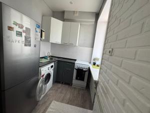 a small kitchen with a washing machine and a washer at 2-х комнатная квартира in Balqash