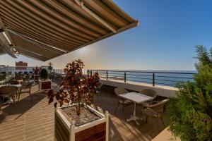 un patio con tavolo e sedie e l'oceano di Hotel Ain benian a Alger