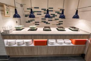 a counter with plates and bowls and pendant lights at Hampton by Hilton Bournemouth in Bournemouth +9 photos