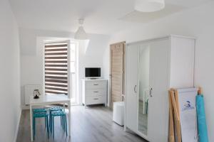 a white room with a desk and a refrigerator at Pensjonat Lazytown in Pogorzelica