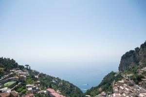 a town on a hill with the ocean in the background at Dimora la Fenice Ambra Apartment in Amalfi