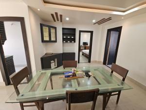 a dining room with a glass table and chairs at The Monarch Riverview 2BHK in Guwahati +2 photos