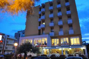 un edificio de hotel con coches estacionados frente a él en Hotel Sirena, en Senigallia