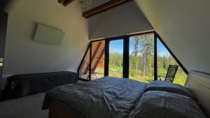 a bedroom with a bed and a large window at Luxusný CHALET DANIELS Tatranská Štrba in Štrba