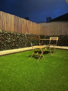 two chairs sitting on the grass in a backyard at Évasion romantique love & spa secteur Thionville Luxembourg in Basse-Yutz