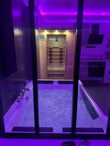 a bathroom with a purple lighting and a tub at Évasion romantique love & spa secteur Thionville Luxembourg in Basse-Yutz +25 photos
