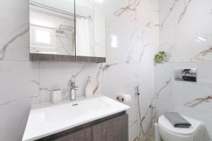 a white bathroom with a sink and a toilet at Sunelia Thassos in Skala Kallirachis +46 photos