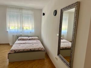 ein Schlafzimmer mit einem Bett und einem Spiegel in der Unterkunft Studio Apartman Centar 2 in Livno