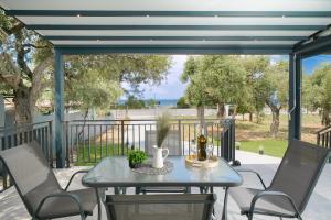a table and chairs on a patio with a view of the ocean at Sunelia Thassos in Skala Kallirachis