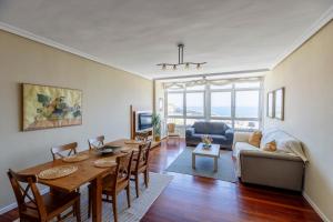 a living room with a table and a couch at San Anton, Ventana al mar in Llanes