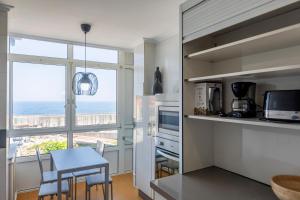 a kitchen with a table and a dining room at San Anton, Ventana al mar in Llanes