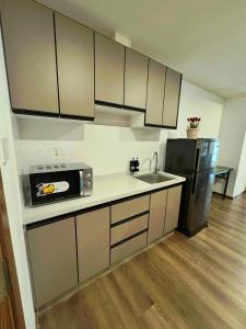 a kitchen with a sink and a microwave at Dee Condo Baguio in Baguio