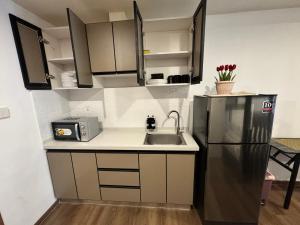 a kitchen with a sink and a refrigerator at Dee Condo Baguio in Baguio +3 photos